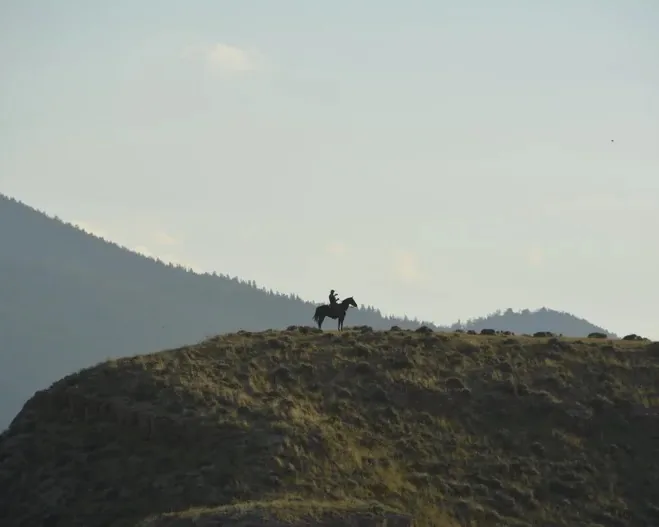 Lone horseback rider on a ridge at Teton Valley Ranch